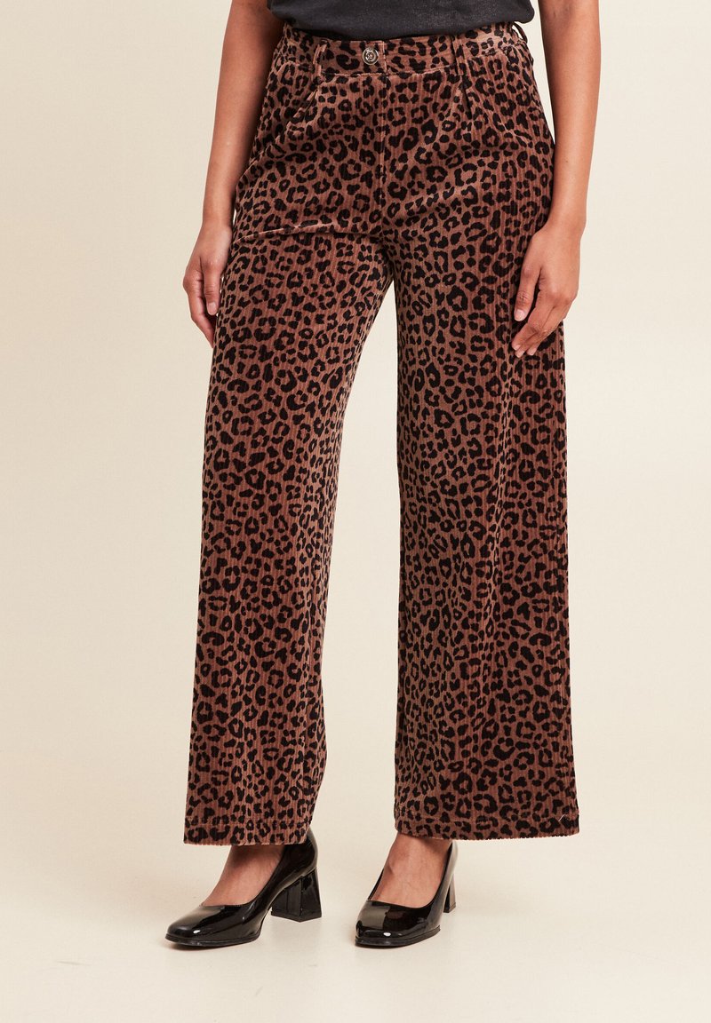 Lederen brede corduroy broeken met luipaardprint in bruin en zwart, met zijzakken en een knoopsluiting, gecombineerd met zwarte hakken.