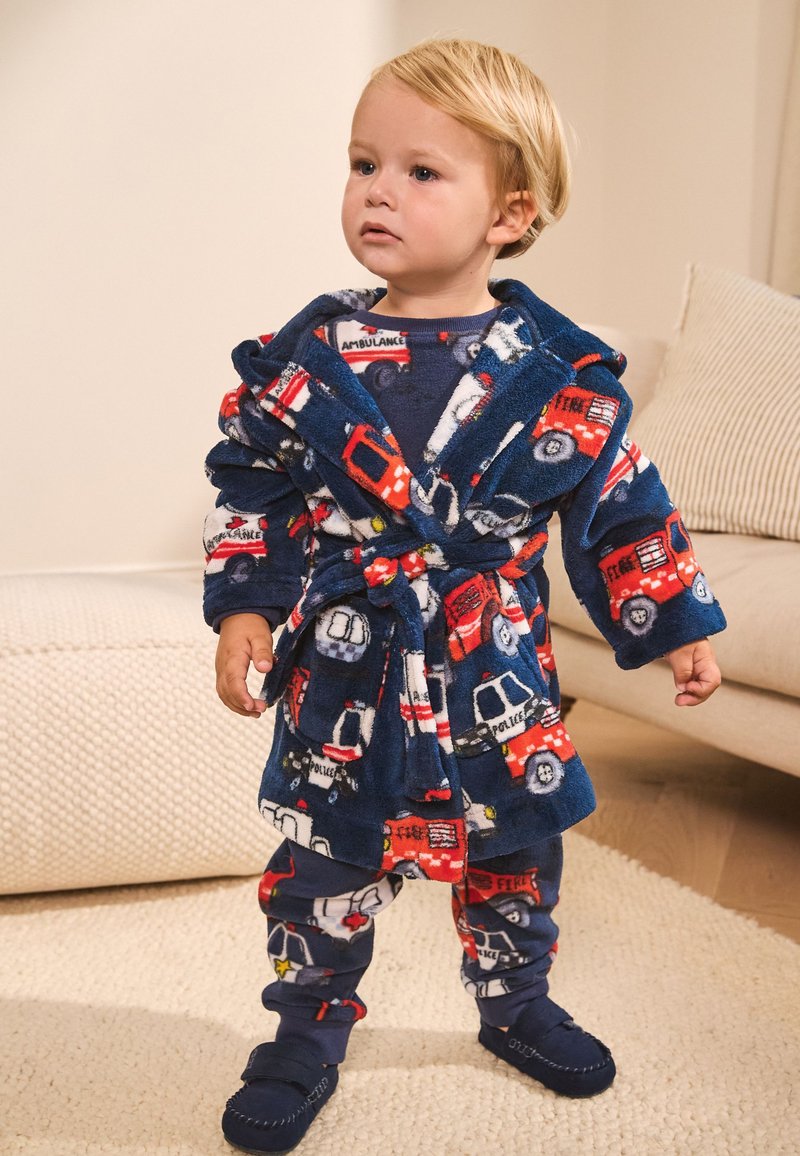 Peignoir pour enfants en tissu peluche bleu marine avec des motifs colorés de camion de pompiers, voiture de police et ambulance ; ceinturé à la taille.