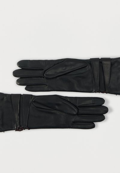 Fekete bőrkesztyű sima textúrával, négy ujjal, megnyúlt csuklóval és dekoratív redőzött részletekkel.