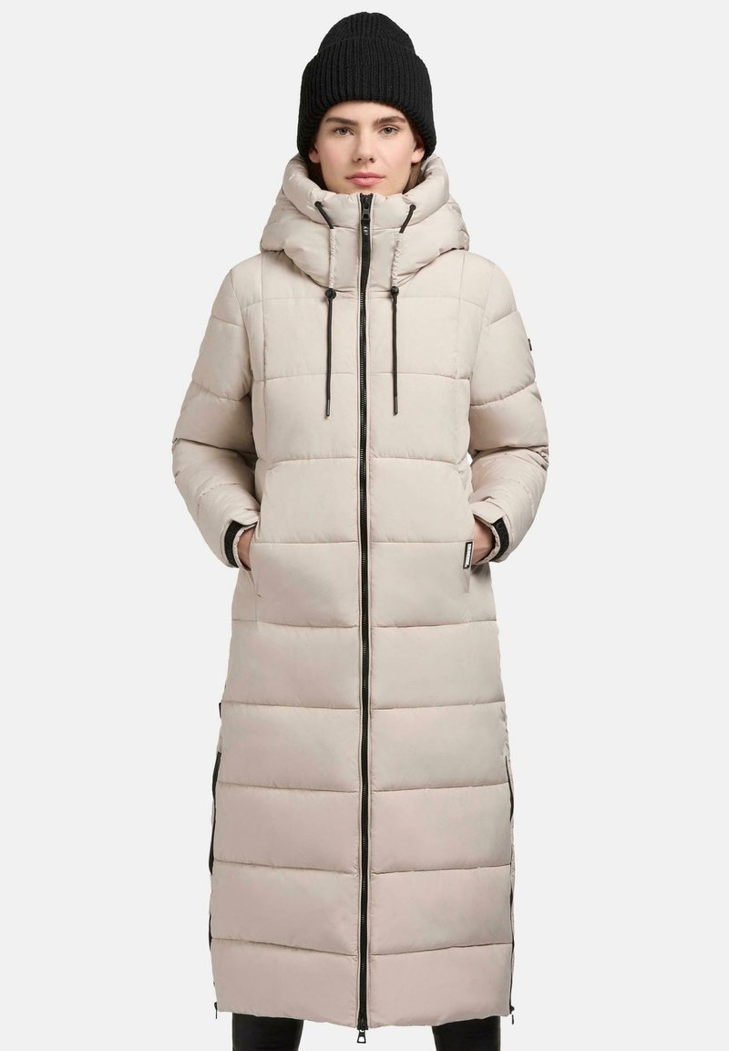 Beige lange pufferjas met horizontale stiksels, een hoge kraag en verstelbare trekkoorden. Beschikt over ritszakken en een tweewegrits.
