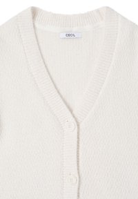 Krémový svetr na knoflíky z měkké texturované látky s výstřihem do V, žebrovanými lemy a třemi bílými knoflíky vpředu. Viditelná značka výrobce.