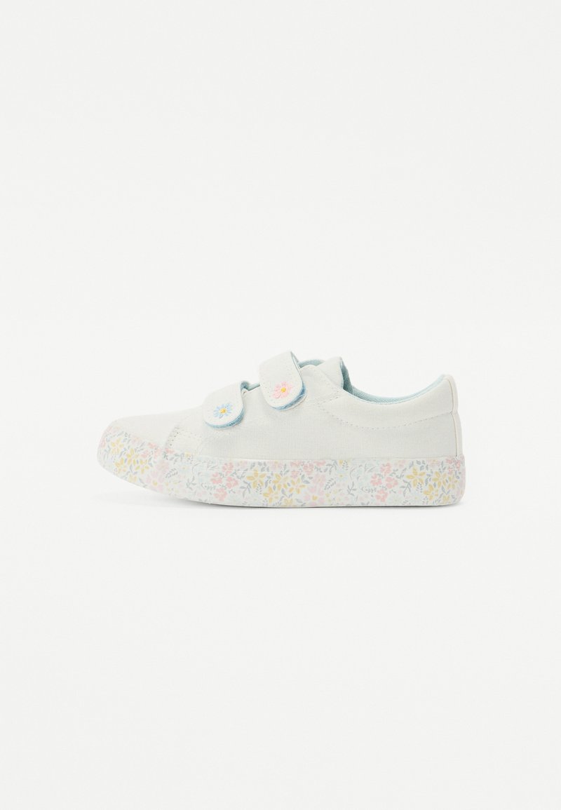 Hvite lerretsko med to justerbare stropper, med en gummisåle med blomstermønster i pastellrosa, gul og blå nyanser.