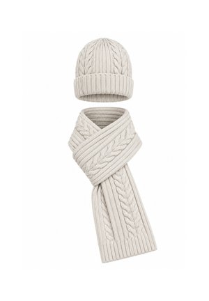 Bonnet en laine tricotée gris clair et écharpe assortie avec motif torsadé sur fond blanc.