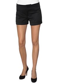 Zwarte op maat gemaakte shorts met een brede tailleband, opgerolde mouwen en een gladde, textuurstof. Draagt zwarte hoge hakken.