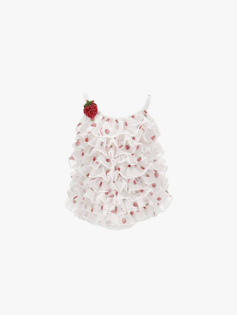 Λευκό βρεφικό ολόσωμο ρούχο με μικρά τυπώματα φράουλας και διακοσμητική φράουλα προσαρτημένη κοντά στον αριστερό ιμάντα του ώμου.