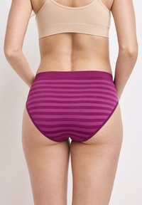Lila randig högmidjade underkläder med en mjuk midjeband, slät textur och en tajt passform, visad bakifrån.