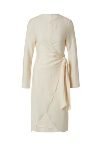Crepe-Wickelkleid in hellem Beige mit langen Ärmeln, seitlichem Bindeband und tiefem V-Ausschnitt. Verfügbar mit strukturierter Oberfläche und einem Ausschnitt auf der Rückseite.