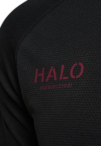 Svart texturerad skjorta med en "HALO"-logotyp i vinröd och ytterligare text nedan, som visar en andningsbar, atletisk design.
