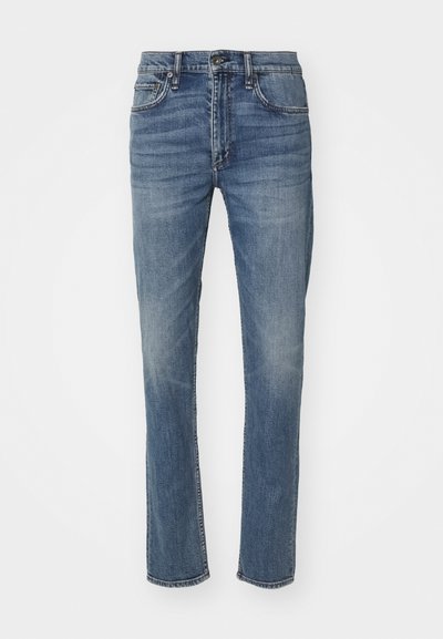 Jean en denim bleu avec une coupe droite, doté d'une fermeture à bouton et à glissière, et d'un design standard à cinq poches. Finition décolorée avec un léger effet de frottement.