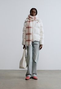 Λευκό μπουφάν puffer, καρό ροζ και λευκό κασκόλ, ανοιχτό μπλε τζιν, ροζ παπούτσια και λευκή τσάντα tote. Απλός σχεδιασμός και απαλές υφές.