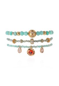 Trois bracelets empilés en turquoise avec des accents dorés et des éléments décoratifs, comprenant une pierre centrale rouge et des pendentifs suspendus.