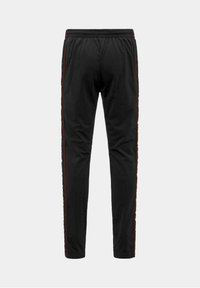 Pantalones deportivos negros con un ajuste ajustado, que presentan franjas laterales rojas, una cintura elástica y una textura de tela suave.