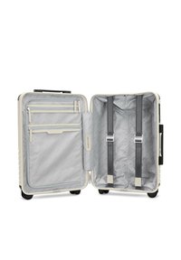 Hartschalentrolley in cremefarben mit grauem Innenraum. Verfügt über mehrere Reißverschlusstaschen, verstellbare Gurte und leichtläufige Rollen.