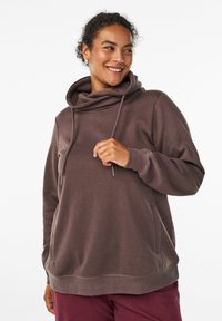 Sudadera con capucha marrón de corte relajado, con bolsillos laterales, detalles de cordones y un tejido texturizado.