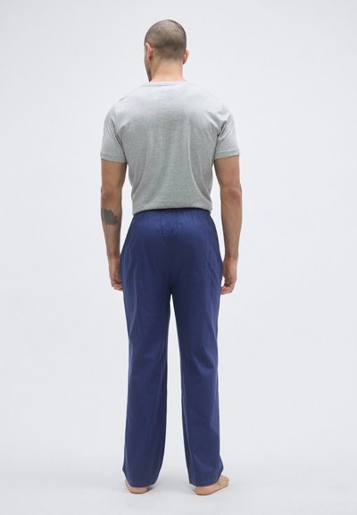 Szara koszulka z krótkim rękawem i granatowe, luźne spodnie. Koszulka ma okrągły dekolt, a spodnie posiadają elastyczną gumkę w pasie.