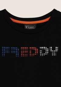 Camiseta negra con el logo "FREDDY" en texto pixelado azul, rojo y blanco. Cuello redondo con un acento naranja. Tejido de algodón suave.