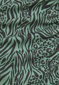 Tissu vert à texture froissée avec des motifs animaliers zèbre et léopard noirs.