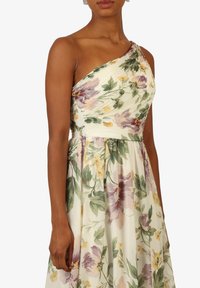 En skulderbåndet blomsterkjole i let stof, med pastelfarvede lilla og gule blomster på en cremefarvet baggrund, struktureret ruching ved bodice.
