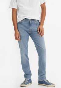 Lyseblå jeans laget av denim, med en avslappet passform, rett ben, klassisk fem-lommersdesign og en subtil falmet tekstur.