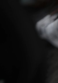 Abstract view of a grey, smooth-textured material with a slightly reflective surface, blending into a dark background.