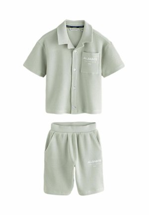Light green short-sleeve shirt and shorts set made from textured fabric; features a pocket and logo on the shirt and shorts.