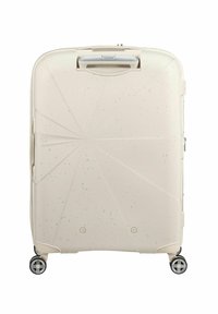 Valigia rigida di colore bianco sporco con una superficie decorata. Dotata di manico retrattile, quattro ruote e leggere macchie sparse.}}