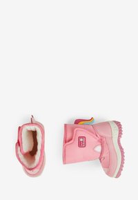 Botas impermeables rosas con forro suave, suela plana, suela de goma texturizada y punta redonda. Presenta un parche de marca y cierre de gancho y bucle.