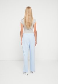 Γκρι μπλούζα με κοντά μανίκια σε συνδυασμό με ανοιχτό μπλε παντελόνι φαρδιάς γραμμής. Απαλό ύφασμα με ελαστική μέση και μινιμαλιστικό σχεδιασμό.