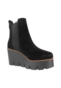 Bottine en suede noire avec panneaux latéraux élastiques, semelle à plateforme épaisse et finition texturée. Elle présente un bout arrondi et un bord cousu.