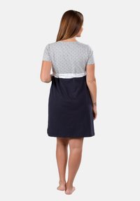 Abito a maniche corte con parte superiore a pois grigi, sezione centrale bianca e gonna blu navy. Realizzato in un tessuto morbido e traspirante.