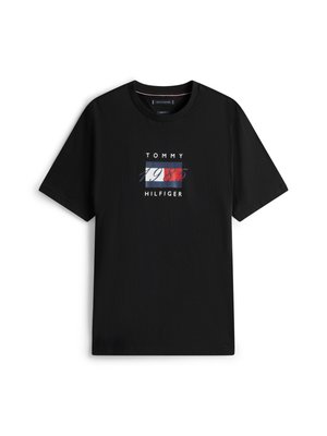 Melna kokvilnas T-kreklā ar īsām piedurknēm, ar centrālu grafiku sarkanā, baltā un zilā krāsā, uz kuras ir teksts "TOMMY HILFIGER" un "1985".
