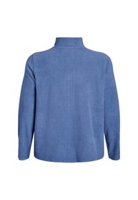 Fleece pullover dalam kain biru lembut, menampilkan kerah tinggi dan lengan panjang. Tekstur halus tanpa pola atau detail perangkat keras yang terlihat.