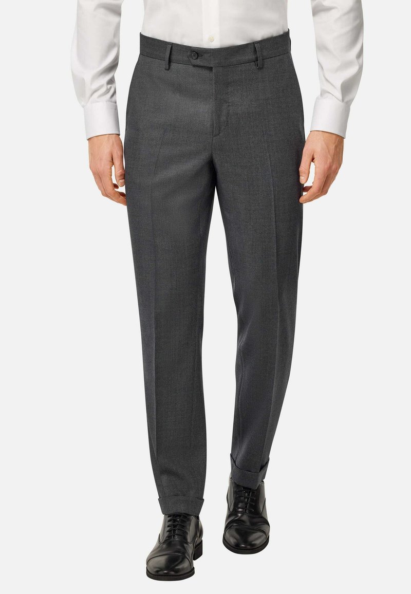 Pantalons gris ajustés avec une coupe slim, dotés d'un devant plat, de passants de ceinture et d'une texture lisse, associés à des chaussures à lacets noires.