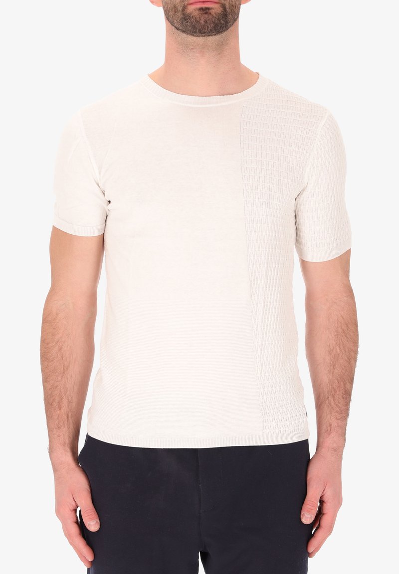 T-shirt a maniche corte di colore crema in maglia, con un pannello a motivo testurizzato su un lato, tessuto liscio dall'altro e scollatura a girocollo.