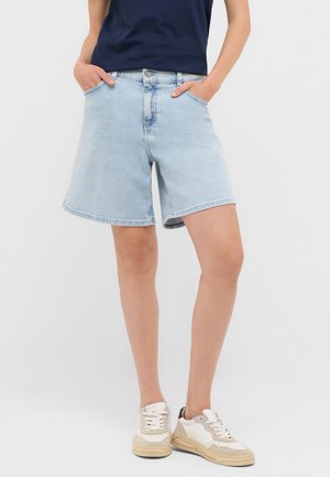 Shorts de mezclilla azul claro con un corte relajado, que cuentan con bolsillos delanteros, un cierre de botón y un dobladillo que queda por encima de la rodilla.