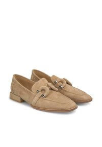 Beige Wildleder Slipper mit flachem Absatz, breitem Riemen und dekorativem Schlaufen, Akzenten in Silberoptik und gestickten Details.