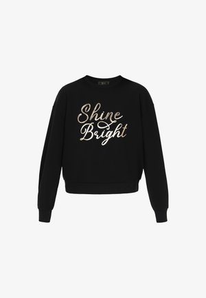 Mustat lyhyet hihattomat collegepaidat, jotka on valmistettu puuvillasta. Edessä on metallinhohtoisella kultakirjaimilla teksti "Shine Bright". Malli on rento ja hihansuissa on resorit.