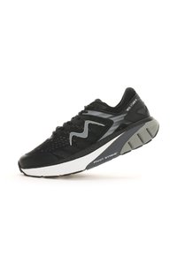 Scarpa sportiva nera con tomaia in mesh, dettagli grigi e suola spessa bianca. Presenta una forma curva pronunciata e superfici testurizzate per una migliore aderenza.