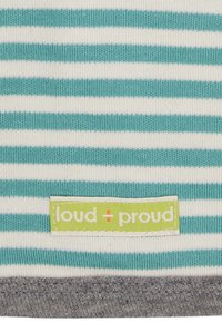 Il tessuto a righe presenta linee orizzontali color turchese e bianche, con un orlo grigio. Un'etichetta verde con il testo "loud + proud" è cucita in fondo.