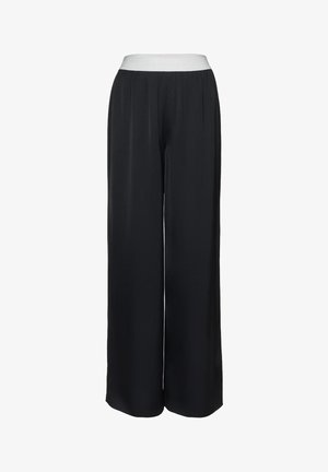 Juodos plačių kojų kelnės su balta elastine juosmens juosta, priekine klostėmis ir lygiu audiniu, pateiktos ant baltos paprastos fonas.