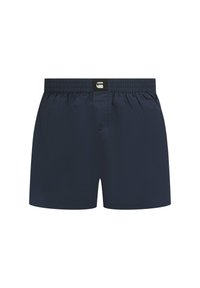 Marineblaue Herrenboxershorts mit elastischem Bund, zentraler Knopfleiste und einem kleinen schwarz-weißen Logo-Patch auf der Vorderseite.