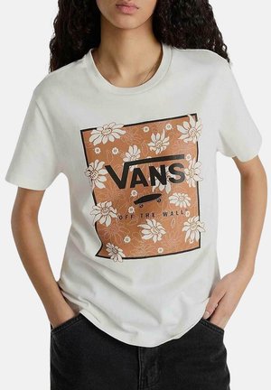 Camiseta de algodón blanca con un gráfico floral marrón que incluye el logo de "VANS" y el texto "OFF THE WALL" en negrita negra, con mangas cortas.