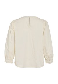 Blouse crème à manches longues avec poignets froncés et petite fermeture par bouton au dos du col.