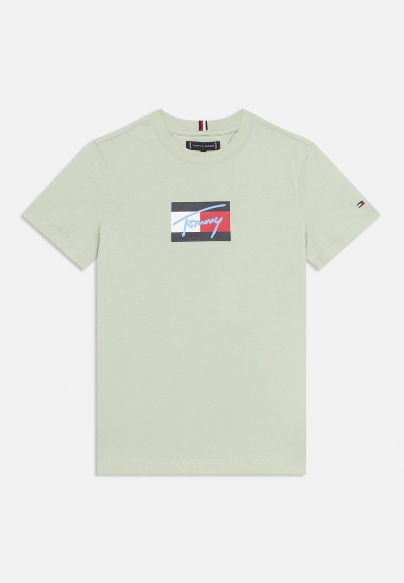 Hellgrünes Baumwoll-T-Shirt mit einem rechteckigen Grafikdesign, das das "Tommy"-Logo in Blau, Rot und Schwarz zeigt. Kurzarm, Rundhalsausschnitt, dezenter Stretch.