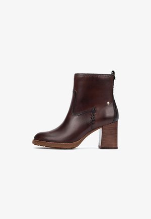 Bottine en cuir marron foncé avec talon bloc en bois, bout arrondi, détails de couture et languette arrière.
