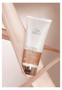 Wella Fusion conditioner tube, 200 mL, wit met een gouden accent, heeft een slank ontwerp, een gladde textuur en bedrukte merkinformatie.
