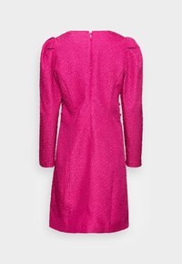 Ljust rosa texturerad klänning med långa puffärmar och dragkedja bak, visad bakifrån på en enkel ljus bakgrund.