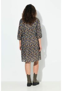 Blumenbedrucktes Kleid mit taillierter Taille, drei Viertelärmeln und lockerer Passform. Das Material ist leicht; die Farben sind Marineblau, Gelb und Türkis.