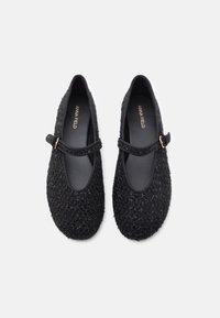 Μαύρες παπούτσια Mary Jane με υφασμάτινη επένδυση, επίπεδη σόλα, στρογγυλή μύτη και διακοσμητική λωρίδα με μεταλλικό κούμπωμα.