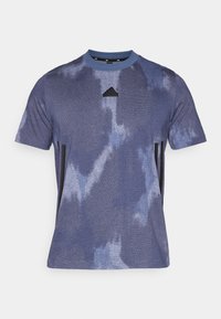 Mönstershortsvärmad blus i blått tie-dye för män med svart Adidas-logotyp och svarta vertikala ränder på sidorna.